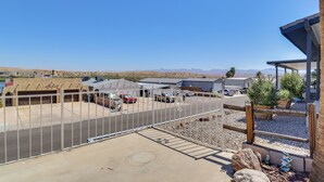A parking area with a fence, a covered structure, and a view of distant mountains. - Riverfront Bullhead City Home w/ Mountain Views! (Bullhead City)