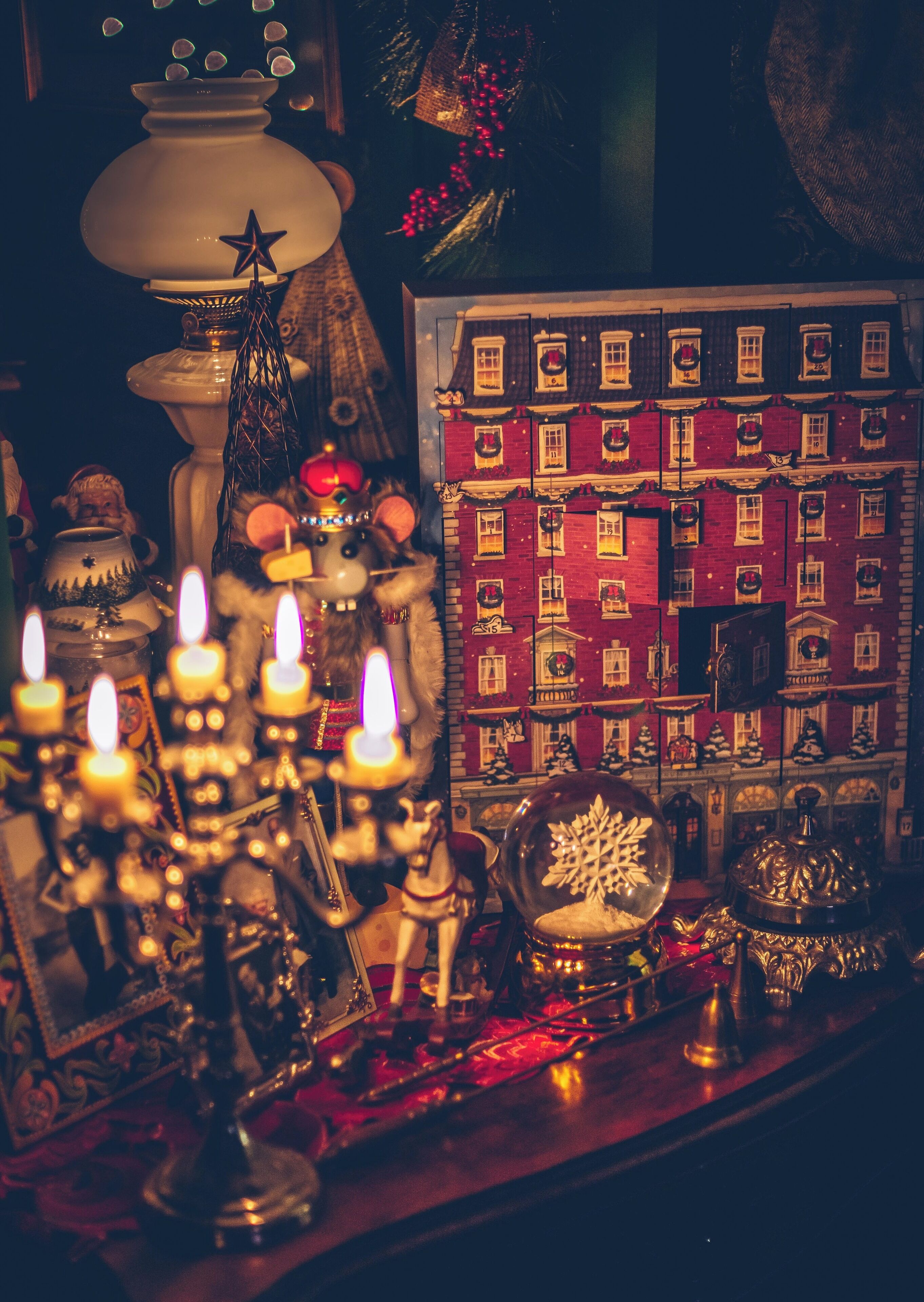 A festive display with a lit menorah, a nativity scene, and a gingerbread house.