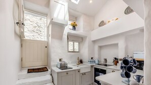 Une cuisine moderne avec des meubles blancs, un four encastré et un évier.