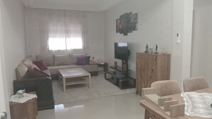 Ein Wohnzimmer mit einer Couch, einem Couchtisch, einem Fernseher und einem Holzschrank.