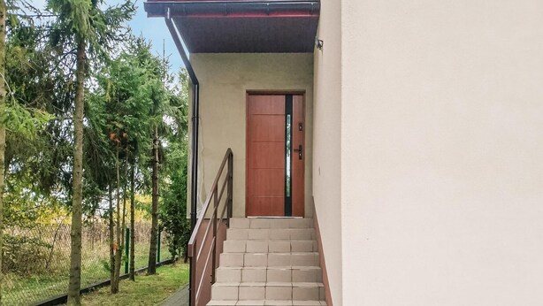 A staircase leading to a wooden door, surrounded by a fence and trees. - Nice apartment in Klucze with WiFi (Klucze)