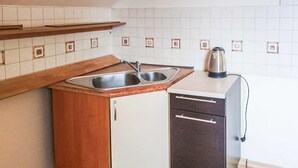 A compact kitchen with a wooden countertop, a double sink, and a small cabinet with drawers. - Nice apartment in Klucze with WiFi (Klucze)
