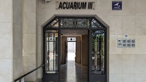 The entrance to Aquarium III with a tiled floor and a metal gate.