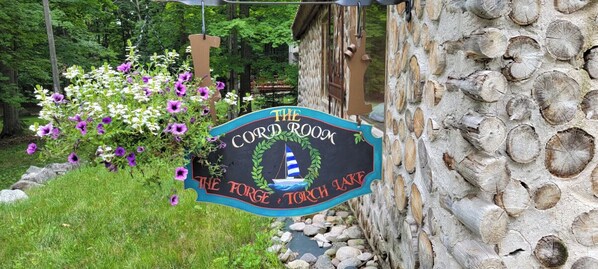 A sign for "The Cord Room" at The Forge Torch Lake, featuring a lighthouse graphic and surrounded by greenery. - The Forge at Torch Lake: near lake access and boat ramp, boat trailer parking (Central Lake)