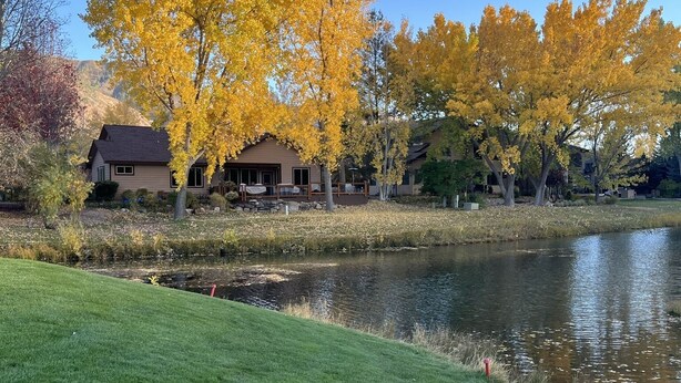 A serene lakeside view with autumn foliage, a stone pathway, and a house with a brown roof. - Winter getaway outside of Durango-  The perfect spot between Purgatory and town! (Durango)