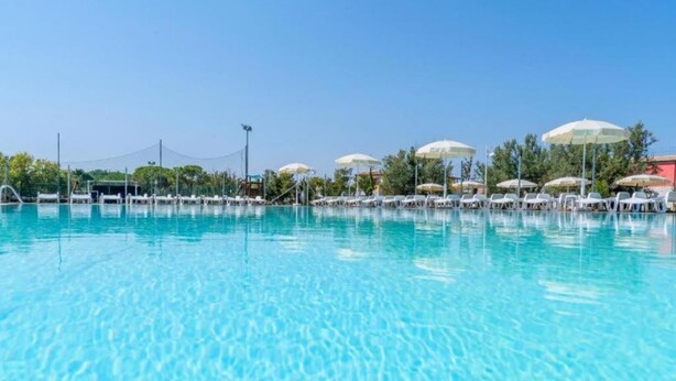 A clear swimming pool with lounge chairs and umbrellas. - M368 - Marcelli, new three-room apartment with garden (Marcelli)