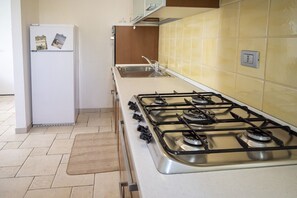 Een koelkast, een oven, een vaatwasser, eettafels