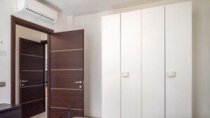 A bedroom with a bed, a wardrobe, and a desk. - M368 - Marcelli, new three-room apartment with garden (Marcelli)
