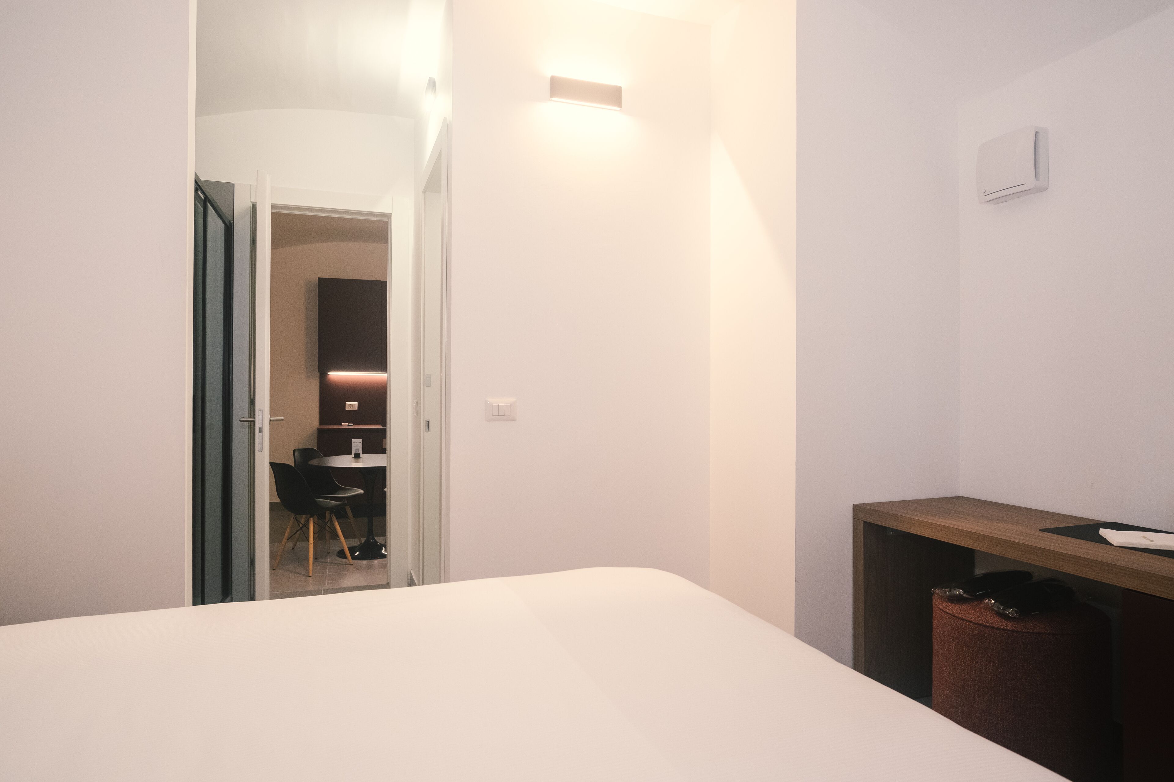 Una habitación de hotel con una cama, un escritorio, una silla y un cesto de basura.