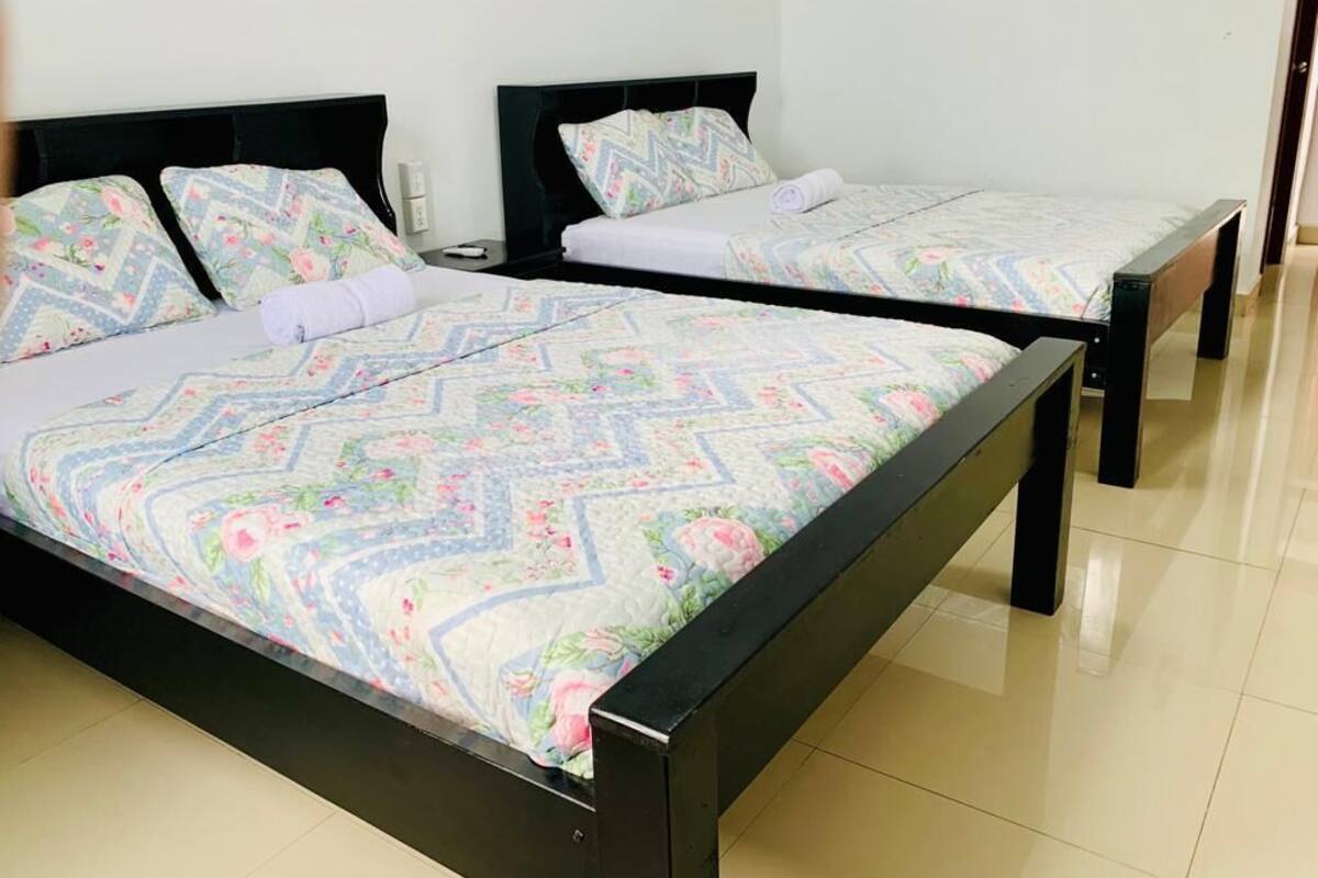 Ein Zimmer mit zwei Betten, jeweils mit einem gemusterten Bettbezug und passenden Kissen.