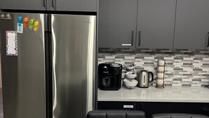 A modern kitchen with a stainless steel refrigerator, a coffee maker, and a kettle on the counter. - House in Sauble Beach hosted by Maleeha and Raza. (Sauble Beach)