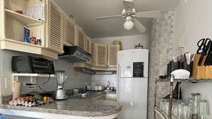 A compact kitchen with a built-in island, microwave, toaster, and refrigerator. - Apartamento Arenas del Edén, Same Club Casablanca (Tonchigüe)