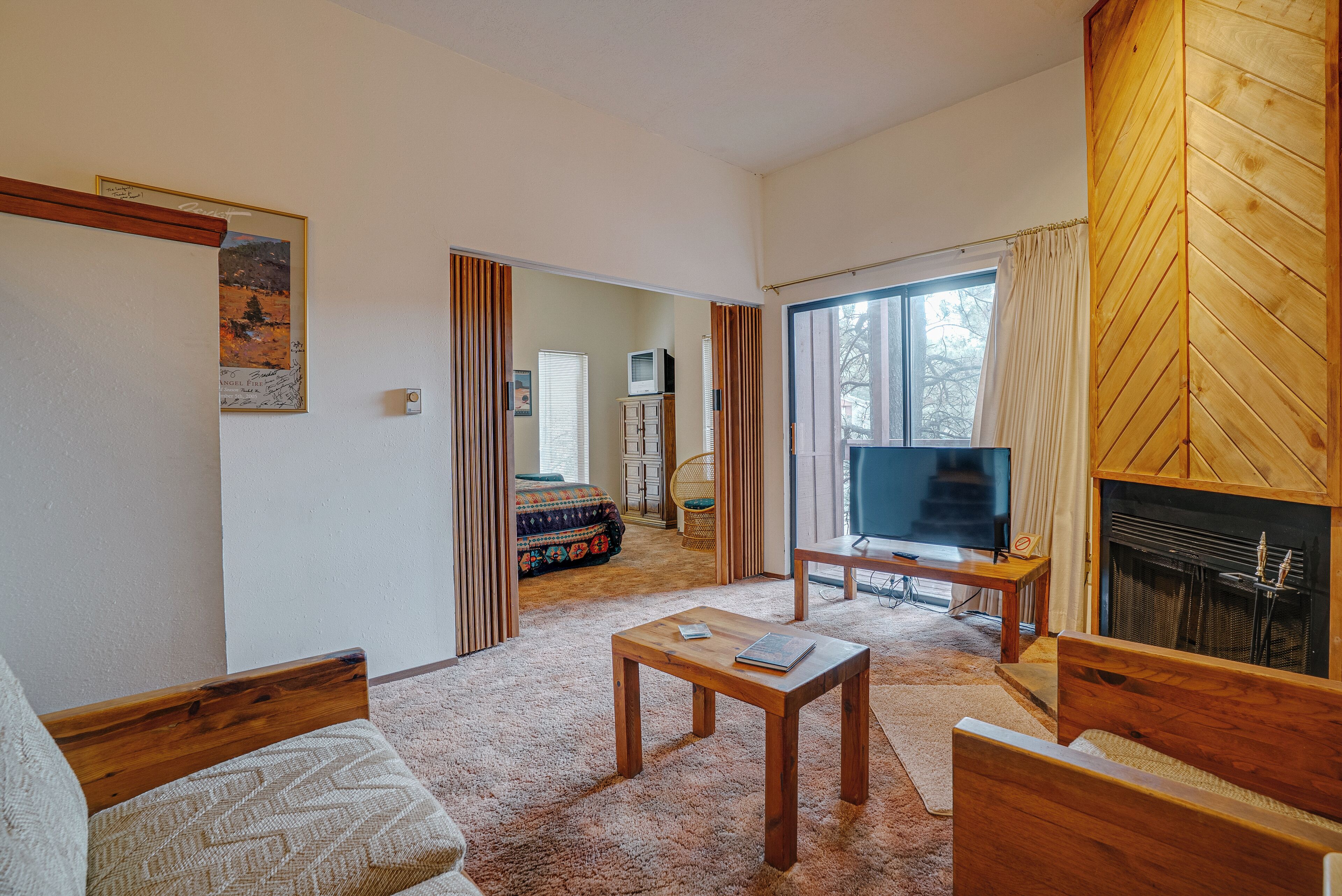 A living room with a fireplace, a television, and a cozy seating area.