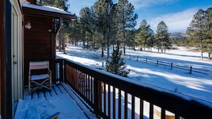 A wooden cabin with a balcony overlooking a snowy landscape with trees. - Townhome with 1st Hole Golf Course Views (Angel Fire)