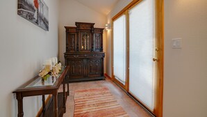 A hallway with a wooden cabinet, a glass table with candles, and a striped rug. - Townhome with 1st Hole Golf Course Views (Angel Fire)
