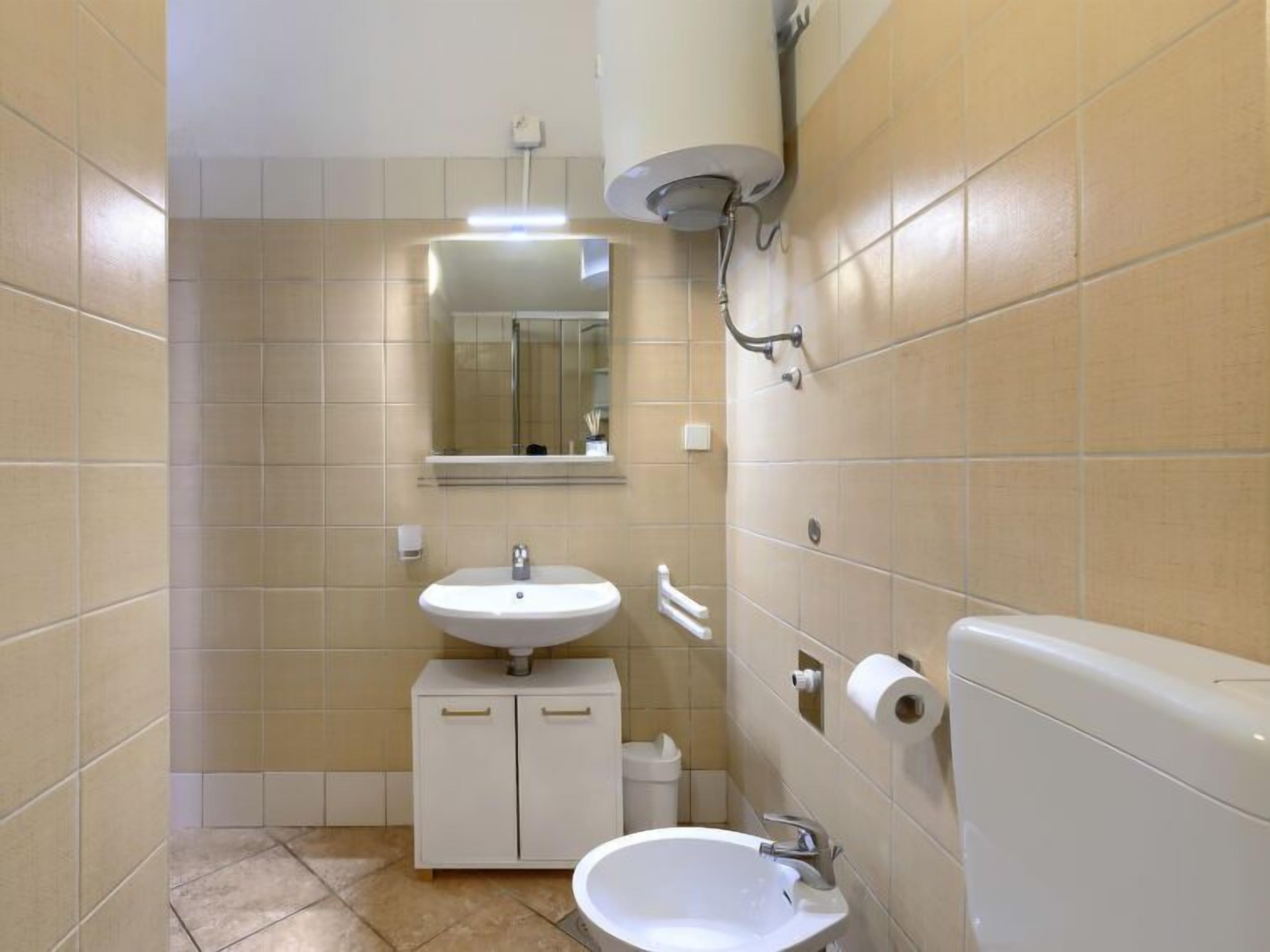 Un bagno piccolo con lavandino, specchio e water.
