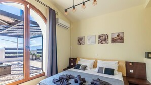 A bedroom with a large bed, a view of the outdoors, and artwork on the wall. - Thrapsano House for up to 8 Persons, Near Iraklion (Minoa Pediada)