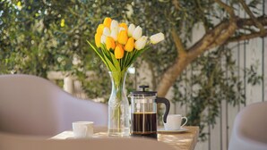 A table with a coffee maker, a cup, and a vase of tulips. - Vanellus Villas Sleeps 6 With Jacuzzi (Pakostane)