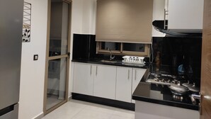 A modern kitchen with a black countertop, white cabinets, and a built-in oven.