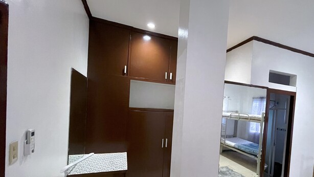 Una habitación compacta con kitchenette, cama y baño.