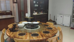 Una mesa de comedor redonda con acabado de madera y sillas con asiento acolchado en azul.