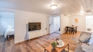 A room with a bed, a TV, a dining table with chairs, and a sofa. - First Street Flat in Downtown Moscow (Moscow)