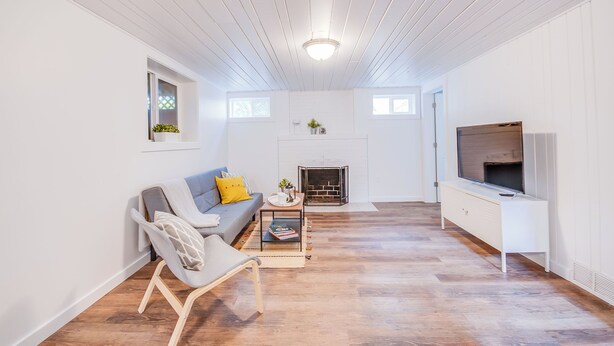 A modern living room with a sofa, armchair, coffee table, fireplace, and TV. - First Street Flat in Downtown Moscow (Moscow)