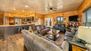 A cozy cabin interior with a living room, dining area, and kitchen.