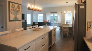 A modern kitchen with a marble countertop, built-in appliances, and pendant lighting. - "Seas the Day", located in the heart of beautiful Corolla, Outer Banks of NC (Corolla)