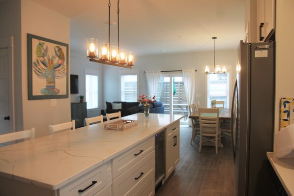 A modern kitchen with a marble countertop, built-in appliances, and pendant lighting. - "Seas the Day", located in the heart of beautiful Corolla, Outer Banks of NC (Corolla)
