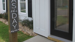 A wooden sign with the text "SEASDAY" and a black door with a window and a light fixture above it. - "Seas the Day", located in the heart of beautiful Corolla, Outer Banks of NC (Corolla)