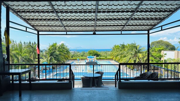 A covered outdoor area with a pool, seating, and a view of the ocean. - Tugsaw Resort (El Salvador)