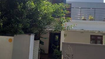 A residential area with a gated entrance, a small covered walkway, and a building with a dark door.
