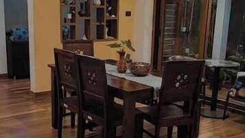 Un coin repas avec une table et des chaises en bois, un miroir décoratif et une plante en pot.