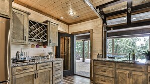Eine Küche mit Holzausstattung, Granit Arbeitsplatten und einem Weinregal.
