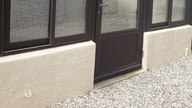 A building with a tiled roof, large frosted glass doors, and a concrete base. - Pavillon Pour 4 Personnes au Bord de L'eau (Leucate)