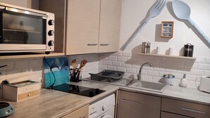 A compact kitchen with a microwave, sink, and washing machine. - Pavillon Pour 4 Personnes au Bord de L'eau (Leucate)