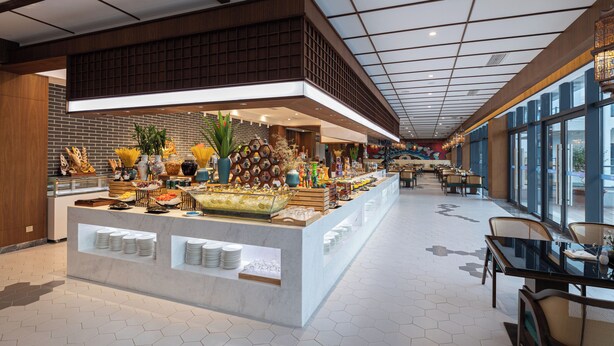 A spacious hotel lobby with a central buffet area, large windows, and a modern ceiling design. - Wuyuan Wunvzhou Wuxiandao Luxury Hotel  (Shangrao)