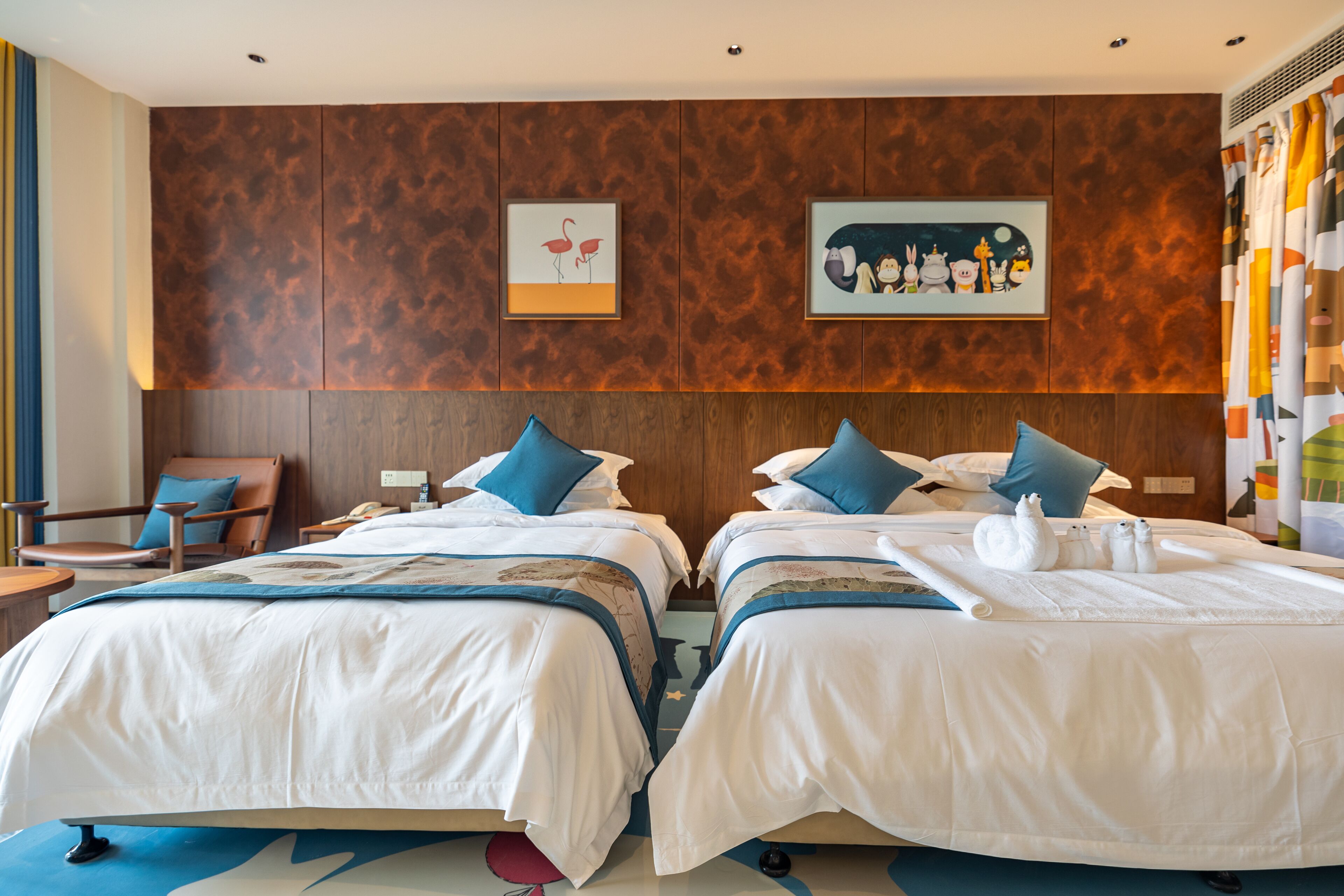 A hotel room with two beds, wooden headboards, and artwork on the walls.
