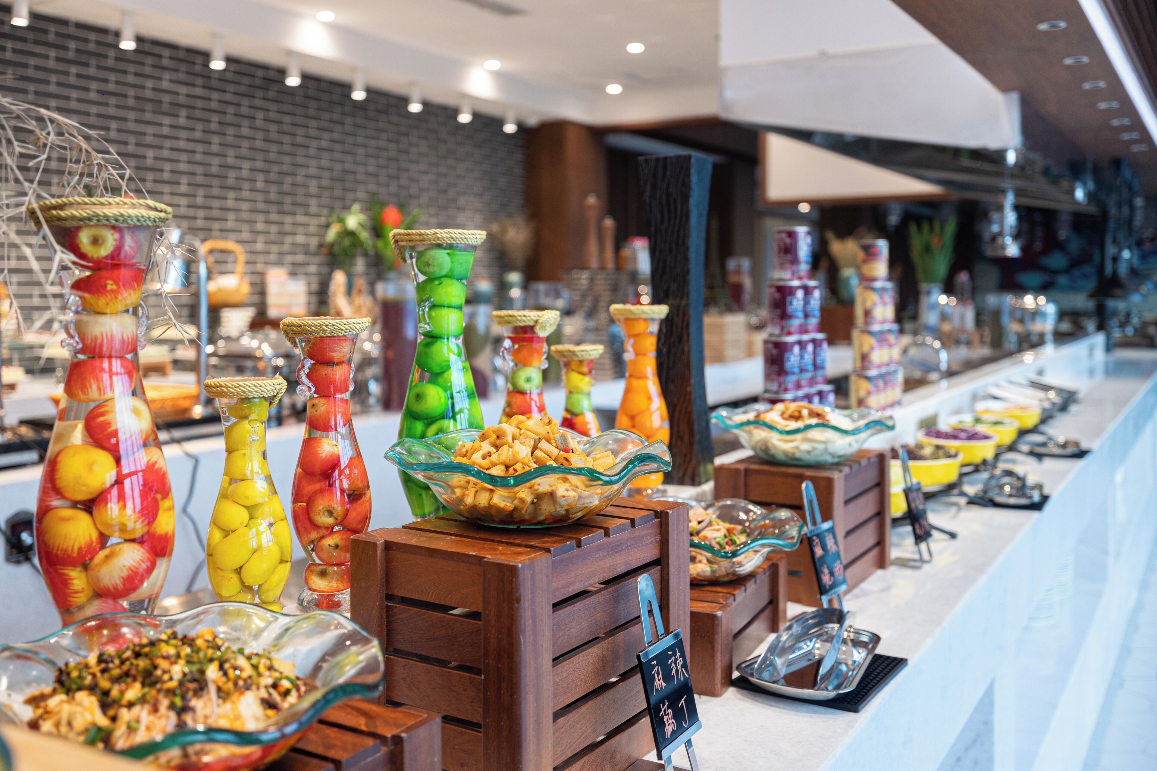 A buffet with various food items and decorative glass containers.