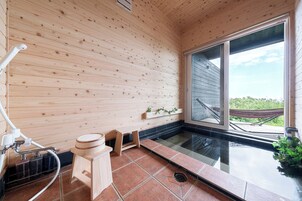 Un interior de madera con un ventanal grande, un taburete de madera pequeño y un piso de baldosas.