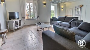 Un salon avec un téléviseur, un canapé et une petite table.