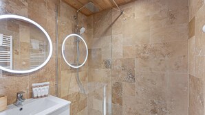 A bathroom with a shower, a sink, and a mirror.