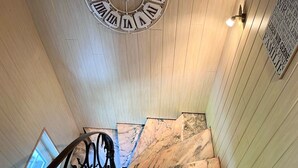 A staircase with marble steps and a decorative wall clock.