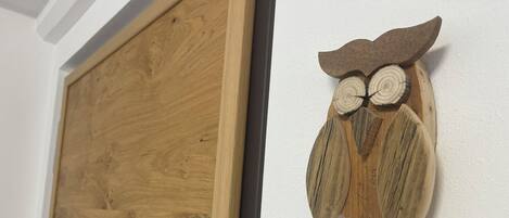 Una puerta de madera con un portero automático incorporado y un adorno de búho de madera en la pared.