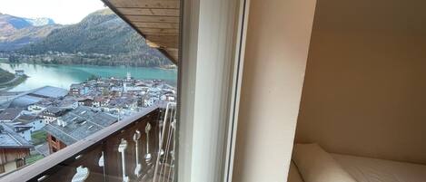 A balcony with a view of a town and a lake.