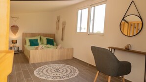A bedroom with a bed, a chair, a bedside table, and a window. - GK Home II part of Gk Fitness Club (Faliraki)