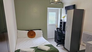A compact bedroom with a bed, a desk, and a wardrobe. - Skyline King Studio Room 201 (Swansea)