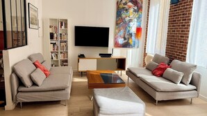 A modern living room with two sofas, a coffee table, and a TV.