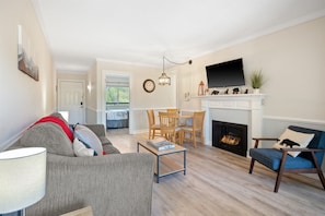 Relax in this inviting living room with a comfortable sofa, armchair, and fireplace.